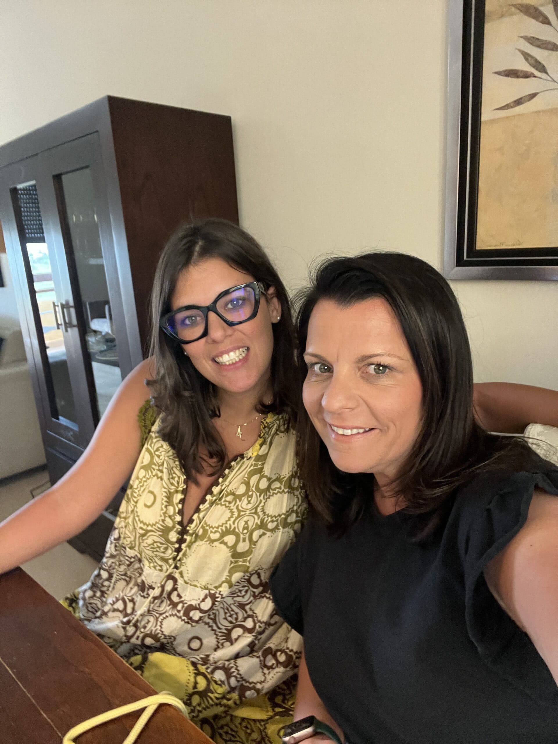 Dos mujeres sonriendo durante una reunión en interior